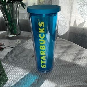 Bright blue Starbucks tumbler with top.